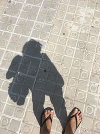 Low section of man standing on sidewalk