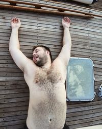 Midsection of man lying down on wood