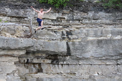 Full length of man jumping off cliff