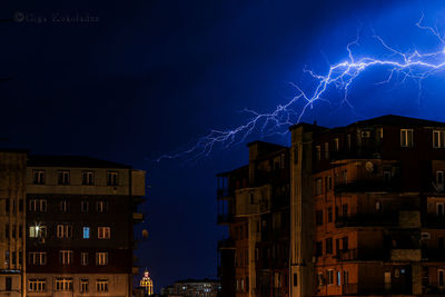 Low angle view of illuminated buildings against sky at night