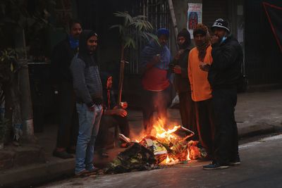 People standing against fire at night