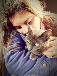 Close-up of young woman with cat
