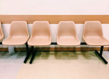 High angle view of empty chairs on table against wall