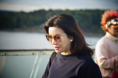 Portrait of woman with sunglasses against blurred background