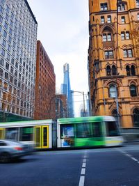 Blurred motion of city street and buildings against sky