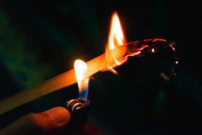 Close-up of hand holding burning candles