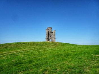 Tower on field against clear sky