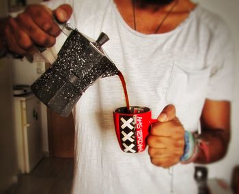 Midsection of man pouring coffee