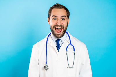 Portrait of smiling young man against blue background