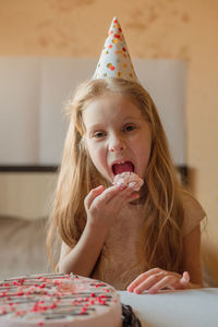 Birthday girl, child without hesitation eats cake with her hands at home. quarantine, isolation