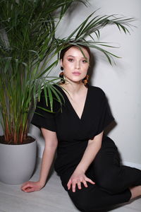 Portrait of young woman standing against white background