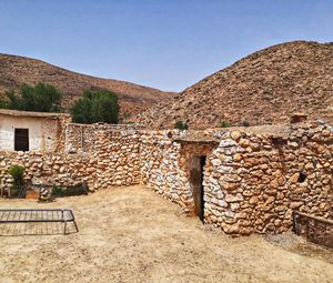 Stone wall of old building against clear sky