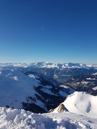 Scenic view of snowcapped mountains against blue sky