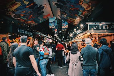 Rear view of people at illuminated market at night