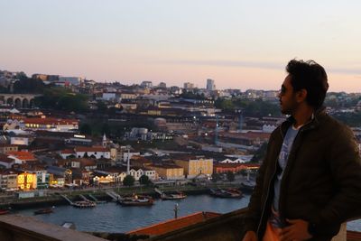 Side view of man looking at cityscape