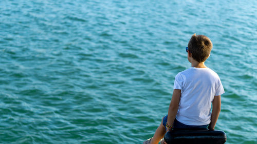 Rear view of man standing against sea
