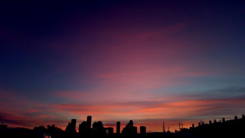 Silhouette cityscape against sky during sunset