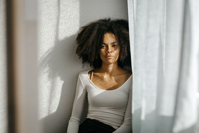 Mixed race woman standing at home against wall