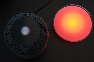 Close-up of illuminated lamp on table against black background