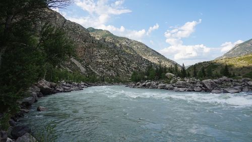 Scenic view of river amidst mountains against sky