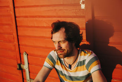 Thoughtful man against wooden wall