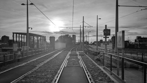 Railroad tracks against sky at sunset