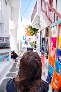 Rear view of woman on road amidst buildings