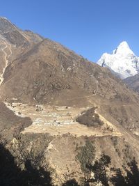 Scenic view of snowcapped mountain against blue sky