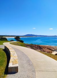 Scenic view of walkway against clear blue sky