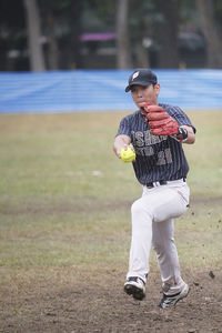 Baseball player throwing ball on field