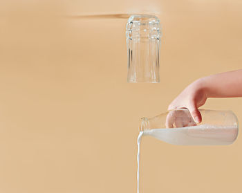 Milk pouring out of a glass bottle. glass turned upside down. creative dairy product concept. 