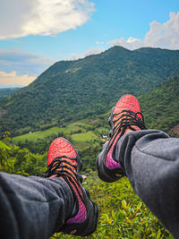 Low section of person wearing shoes on land