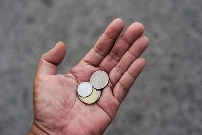 Close-up of hand holding coins