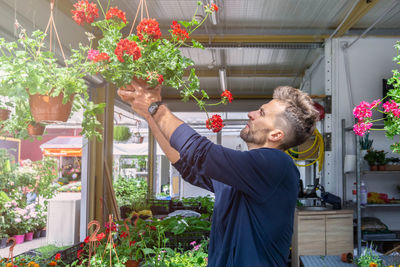 Side view of man holding flower pot