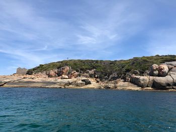 Rock formations by sea against sky