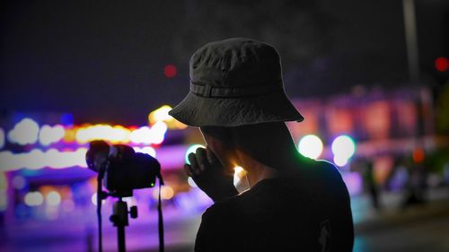 Man by camera at night