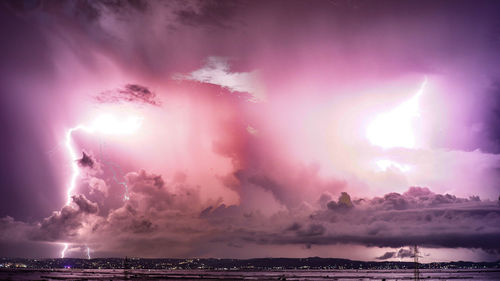 Lightning show over sea against sky during sunset
