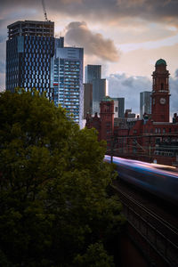 Buildings in city against sky during sunset