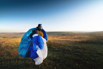 Portrait of woman standing on field against clear sky