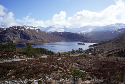 Scenic view of lake by mountains against sky