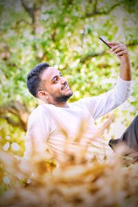 Portrait of young man holding plant