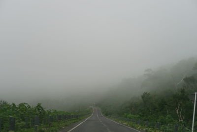 Road amidst trees against sky