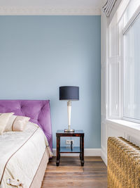 Gold retro heater under a large window in a bright spacious room close-up