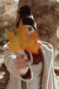 Portrait of young woman holding camera