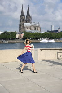 Full length portrait of smiling young woman in river