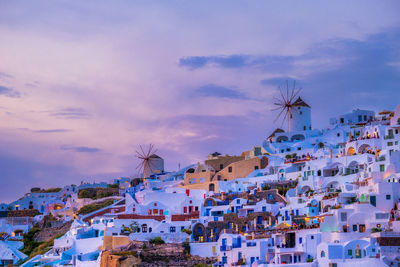 Houses in town against cloudy sky