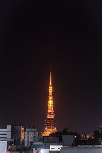 Illuminated buildings against sky at night