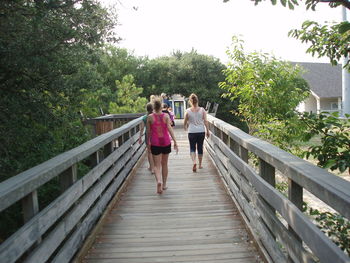 Friends running on footbridge