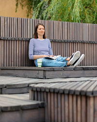 Woman reads a book and rests in a public place drinks coffee. european woman meditates in the park