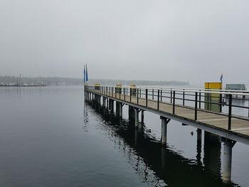 Pier on calm sea against clear sky